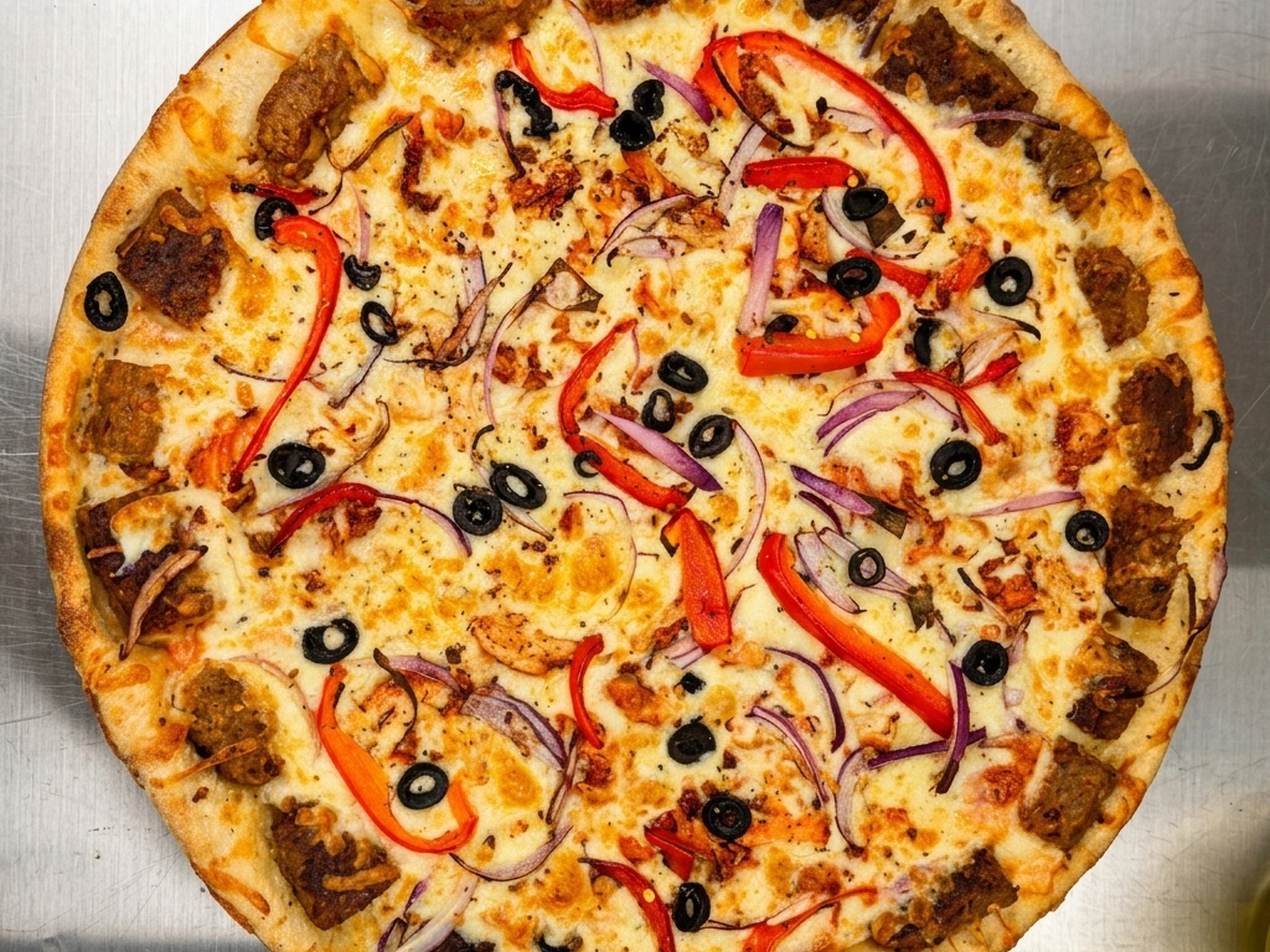 Achari chicken pizza at Calzone Corner Takeout & Tiffin Service Calgary - Punjabi pizza with tangy achari-spiced chicken