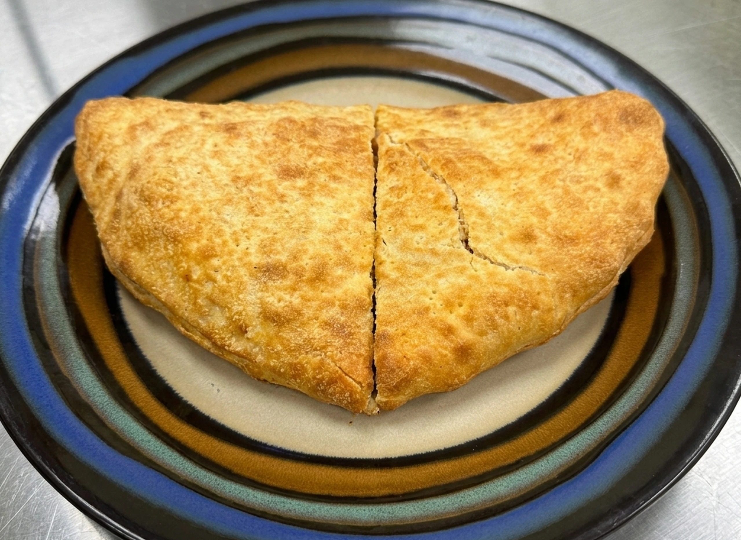 Chicken malai tikka calzone at Calzone Corner Takeout & Tiffin Service Calgary NE - creamy malai tikka chicken in a baked calzone