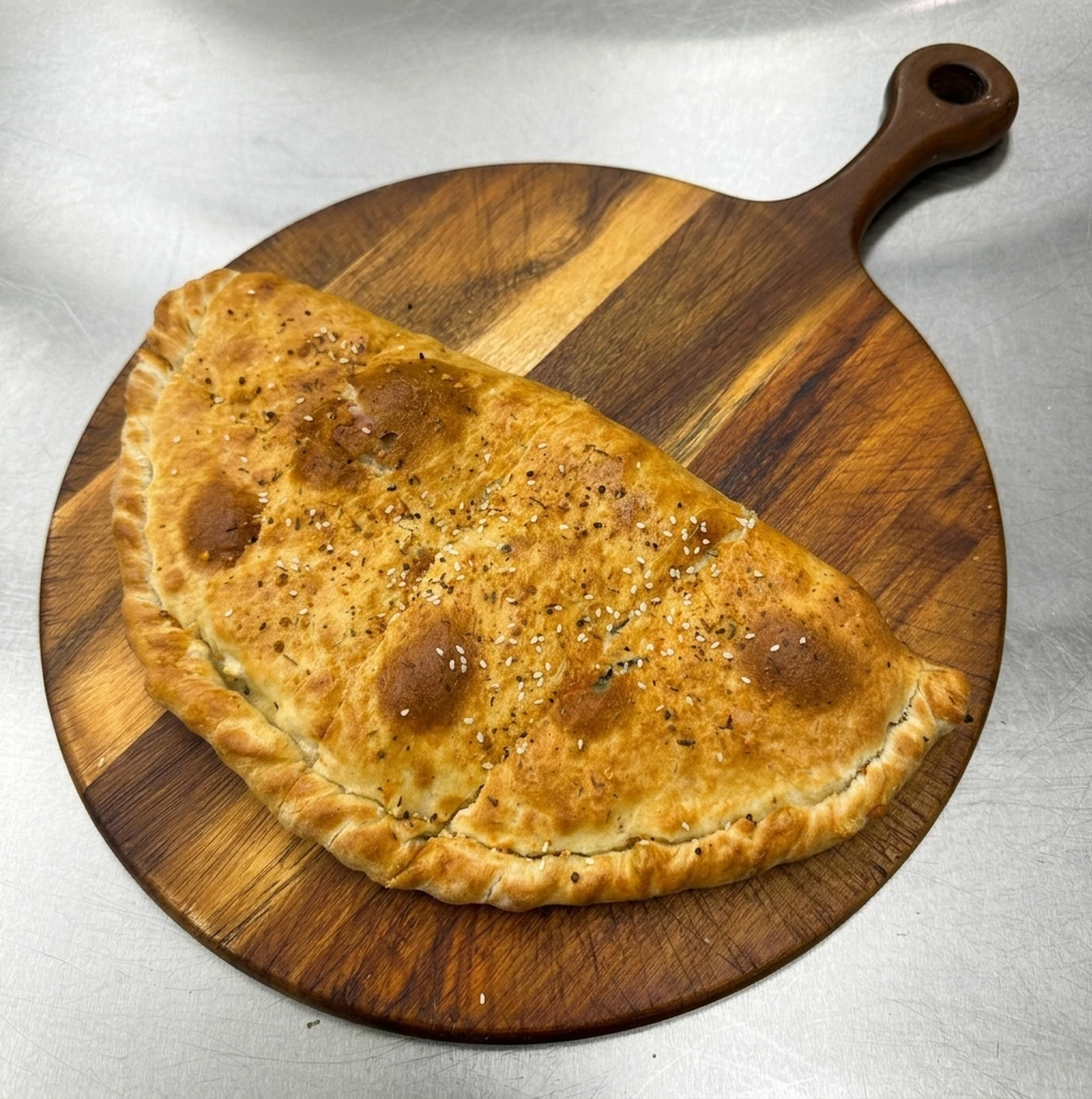 Masala chicken calzone at Calzone Corner Takeout & Tiffin Service Calgary NE - golden-baked calzone with Punjabi masala chicken filling